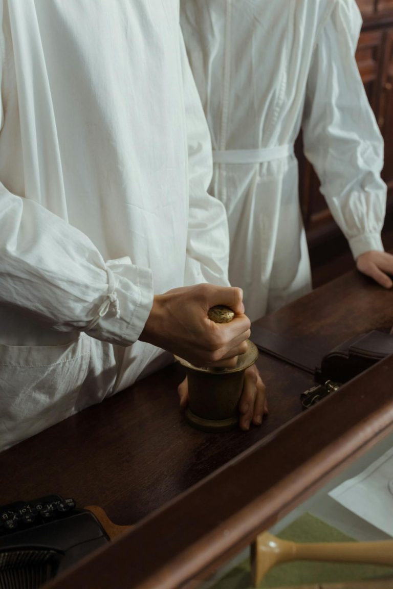 Individuals in lab coats using mortar and pestle for experiments in a vintage laboratory.